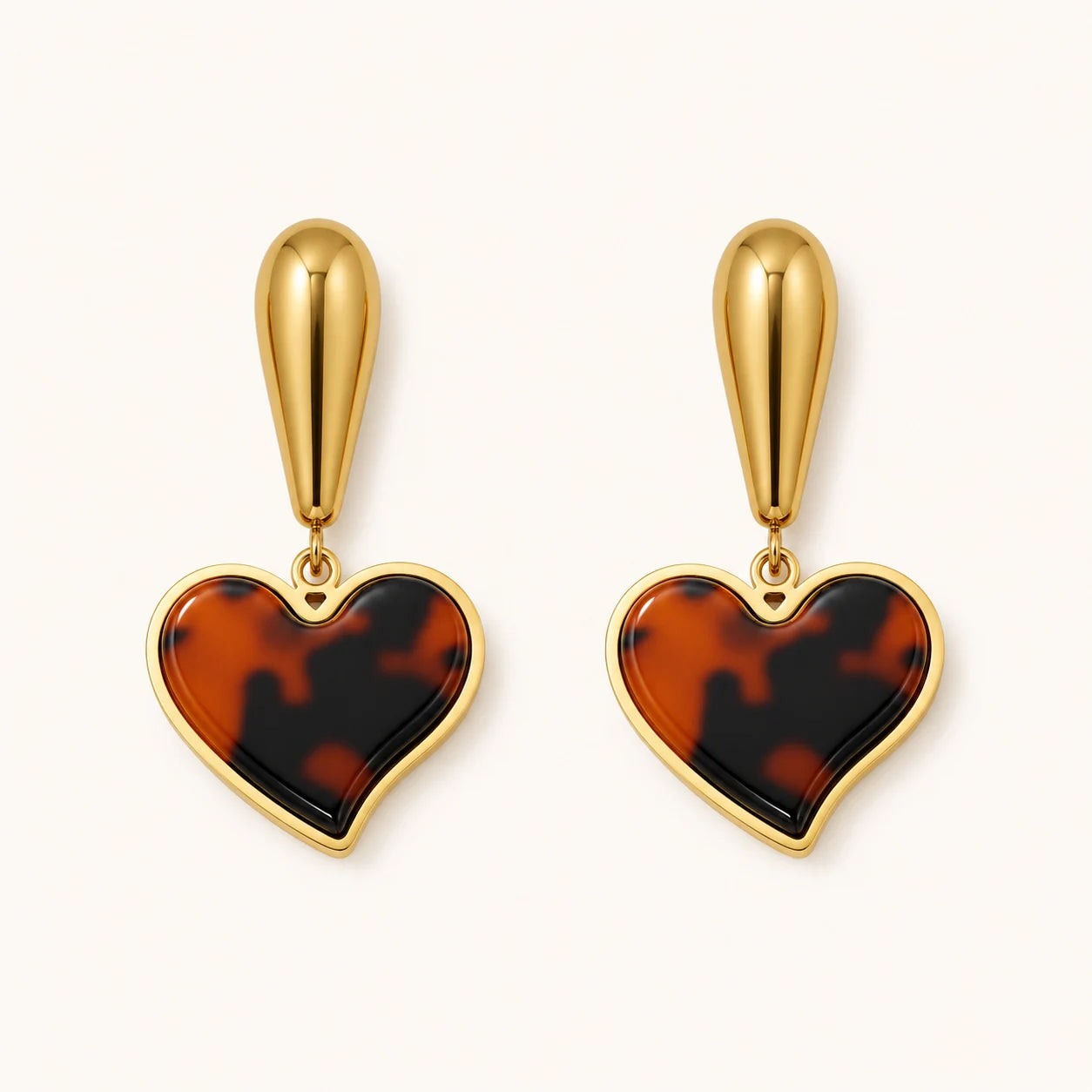 Heart-shaped tortoiseshell earrings with gold accents on a white background