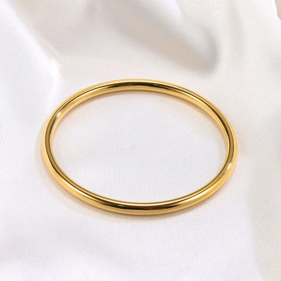Gold bangle on a white fabric background