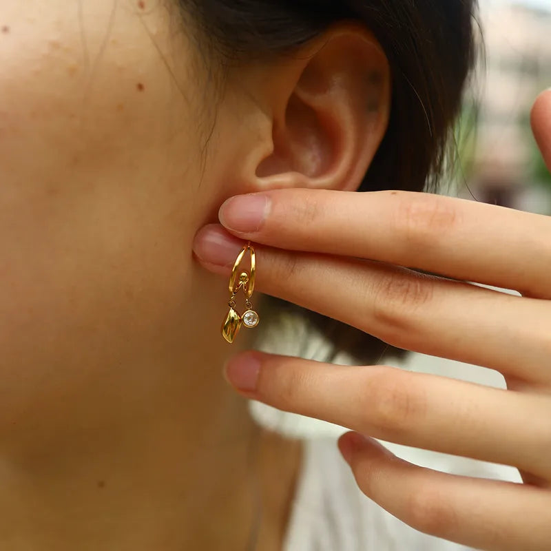 Close-up of a person wearing a gold hoop earring with a blurred background