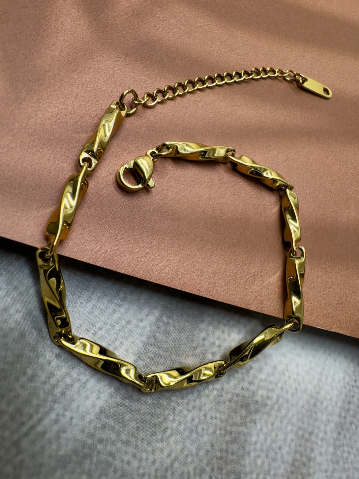 Gold chain bracelet on a textured surface